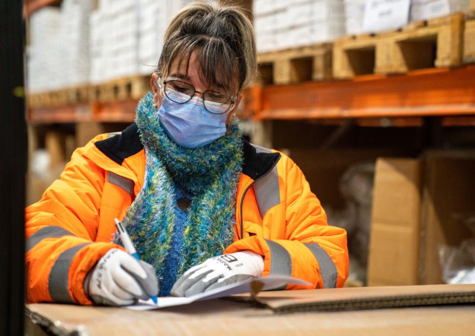 Woman in plant warehouse signing delivery order