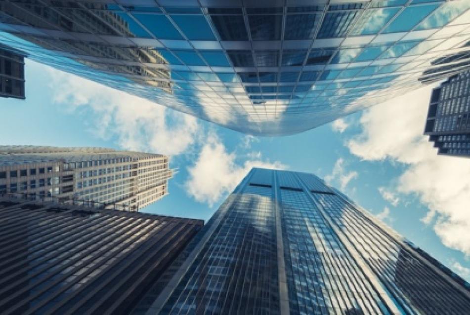looking up into sunny sky with skyscrapers on all sides
